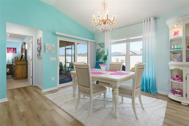 6576 Merrill Ln, The Villages, FL 34762 - dining area featuring baseboards, vaulted ceiling, a chandelier, and light wood-type flooring