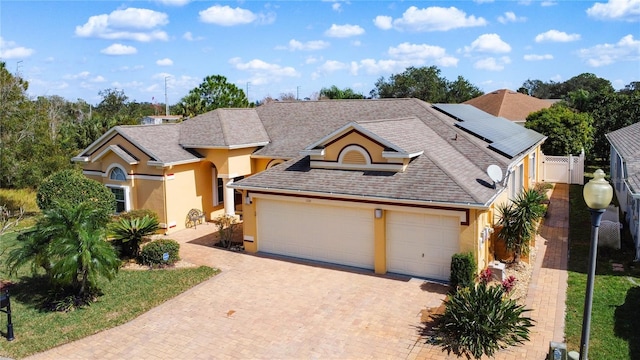 view of front of property featuring a garage and solar panels