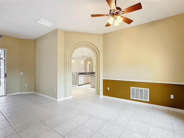 spare room featuring sink, light tile patterned floors, and ceiling fan