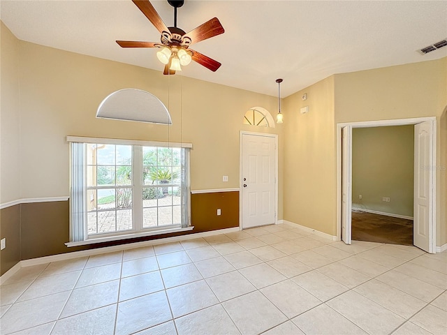 unfurnished room featuring ceiling fan, lofted ceiling, and light tile patterned floors