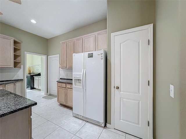 kitchen featuring light tile patterned flooring, light brown cabinetry, white refrigerator with ice dispenser, and decorative backsplash