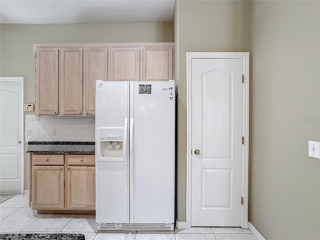 kitchen featuring tasteful backsplash, light tile patterned floors, white fridge with ice dispenser, and light brown cabinets