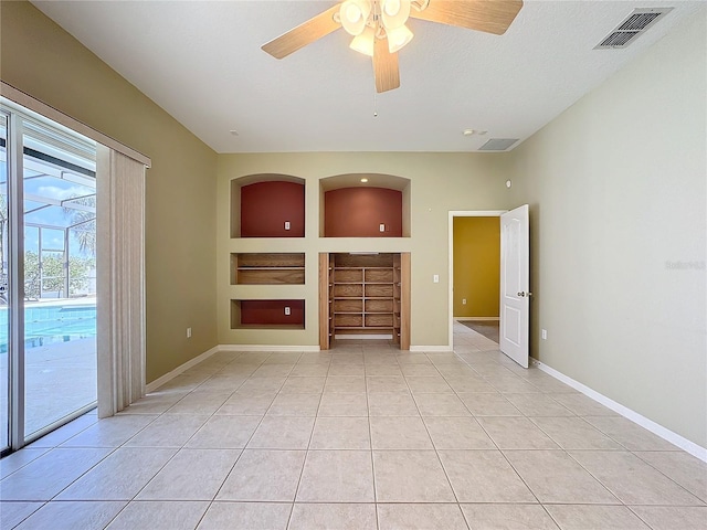 unfurnished living room with ceiling fan, a textured ceiling, built in features, and light tile patterned floors