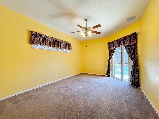 carpeted empty room featuring ceiling fan and a textured ceiling