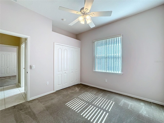 unfurnished bedroom featuring ceiling fan, carpet floors, a closet, and a textured ceiling