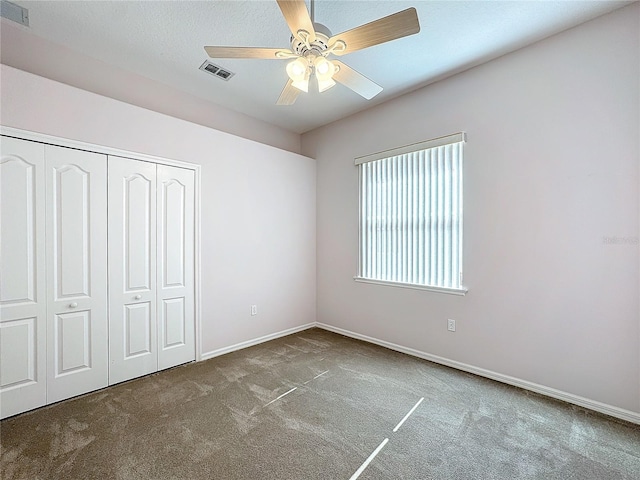 unfurnished bedroom with carpet, a textured ceiling, ceiling fan, and a closet