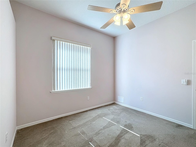 carpeted spare room featuring ceiling fan