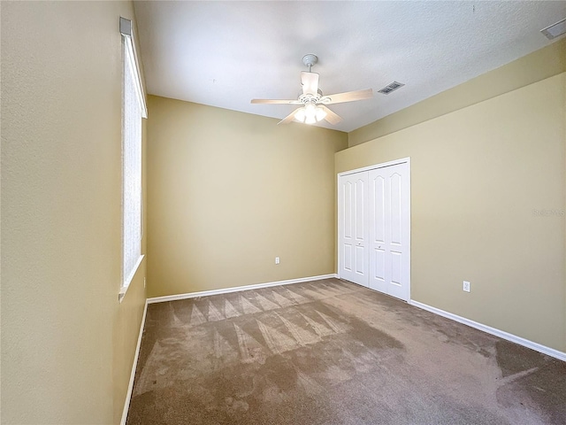 unfurnished bedroom featuring ceiling fan, a closet, and carpet