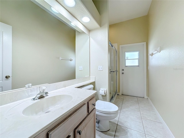 bathroom featuring tile patterned floors, toilet, a shower with shower door, and vanity