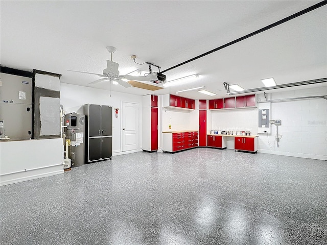 garage featuring a garage door opener, water heater, ceiling fan, electric panel, and heating unit