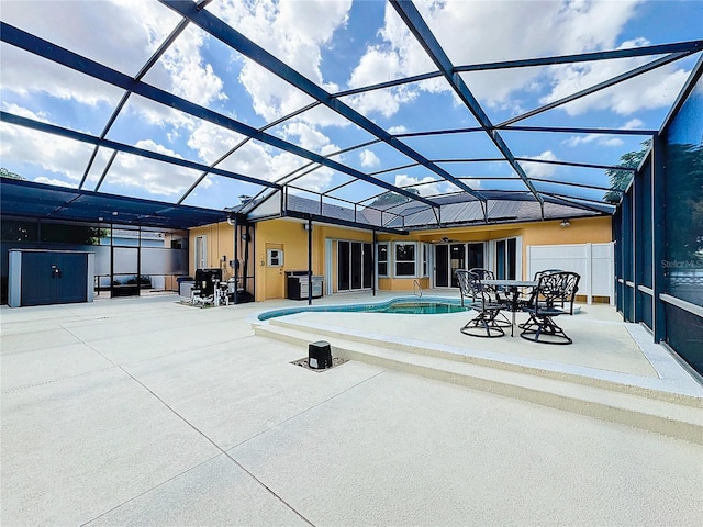 view of pool featuring a jacuzzi, a patio area, and glass enclosure