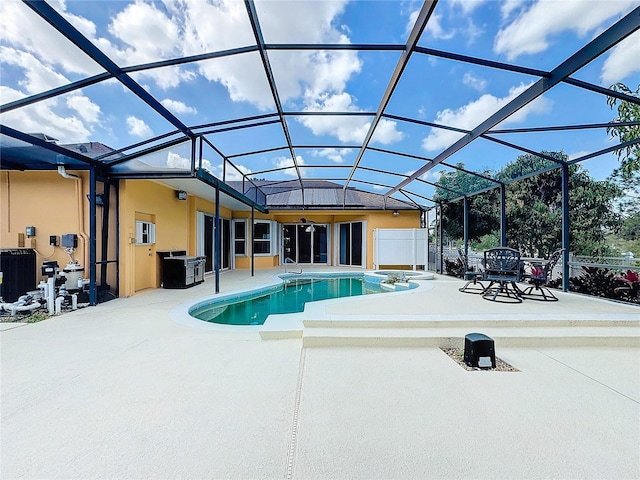 view of pool with glass enclosure and a patio area