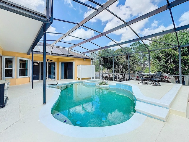 view of swimming pool featuring an in ground hot tub, a patio area, and glass enclosure