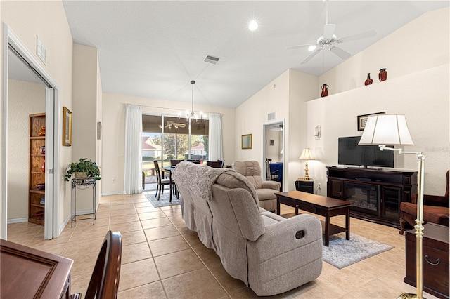 living area with lofted ceiling, light tile patterned floors, ceiling fan with notable chandelier, and visible vents