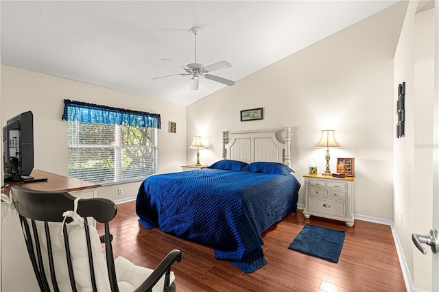 bedroom with a ceiling fan, vaulted ceiling, baseboards, and wood finished floors