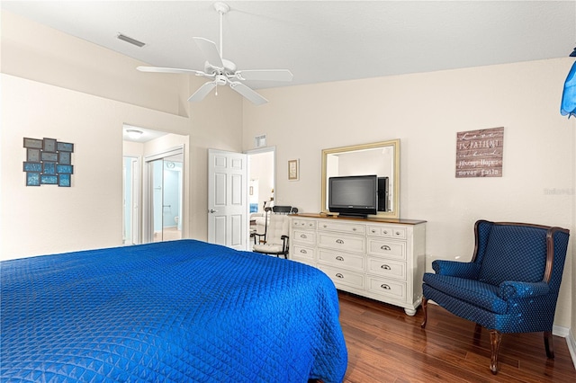 bedroom featuring ceiling fan, connected bathroom, visible vents, vaulted ceiling, and dark wood-style floors