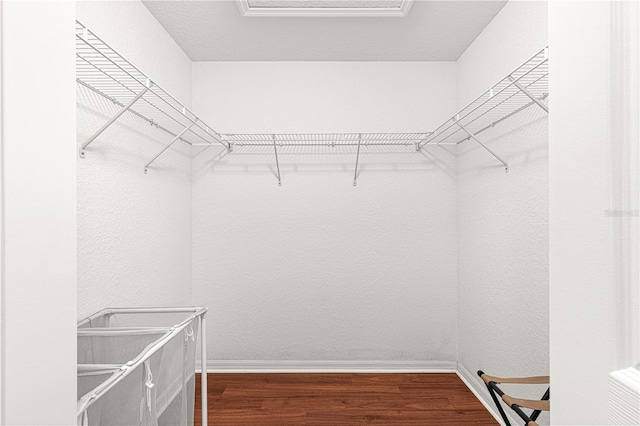 spacious closet featuring attic access and wood finished floors