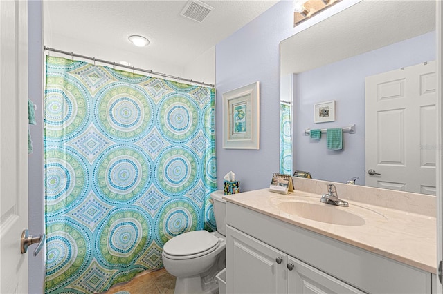 bathroom featuring toilet, a textured ceiling, vanity, and visible vents