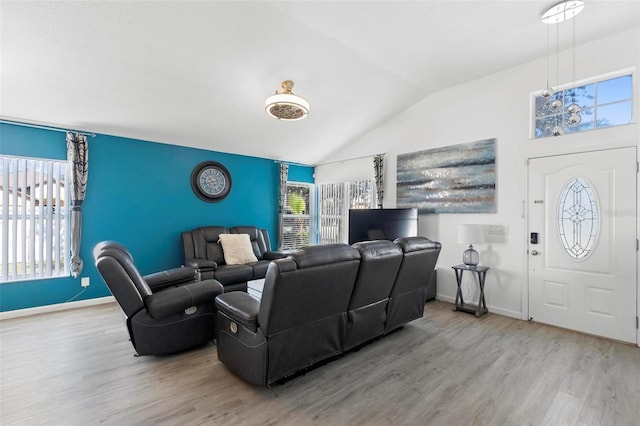 living room with vaulted ceiling, wood finished floors, and baseboards