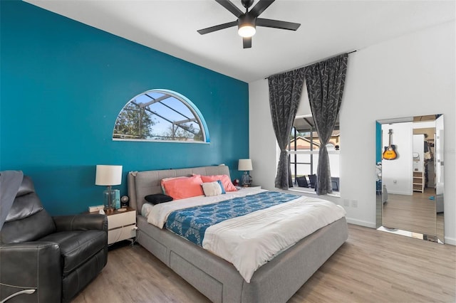 bedroom with multiple windows, baseboards, and wood finished floors