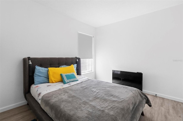 bedroom featuring baseboards and wood finished floors