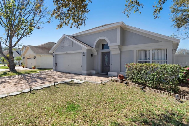 single story home featuring a garage, driveway, a front lawn, and stucco siding