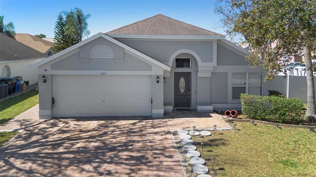 view of front of house with a shingled roof, decorative driveway, an attached garage, and stucco siding