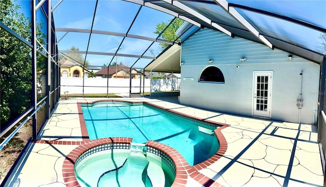 view of pool featuring a pool with connected hot tub, glass enclosure, a patio, and fence