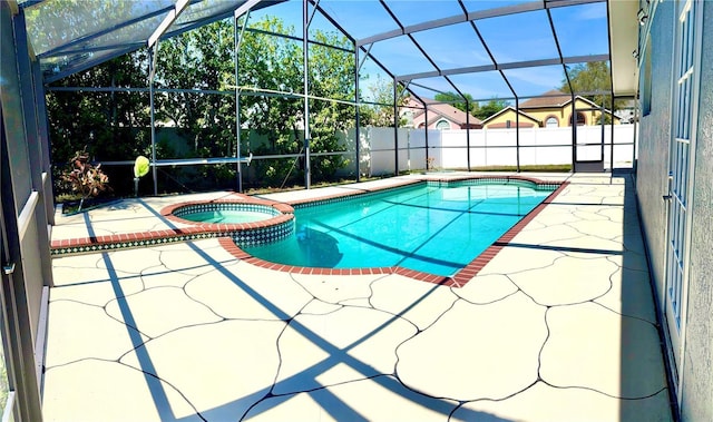 view of pool featuring a patio area, a lanai, a pool with connected hot tub, and fence