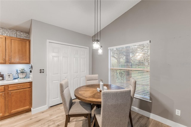 dining room featuring light hardwood / wood-style flooring and vaulted ceiling