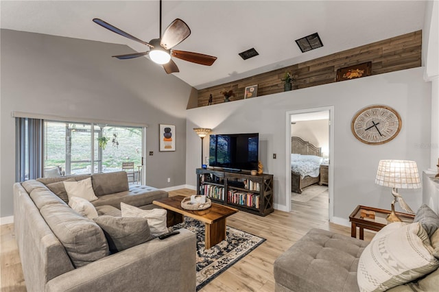 living room featuring ceiling fan, light wood-type flooring, and high vaulted ceiling