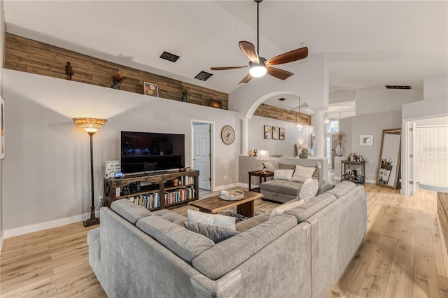 living room featuring ornate columns, ceiling fan, high vaulted ceiling, and light hardwood / wood-style floors