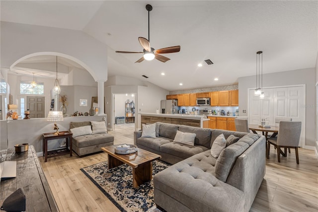 living room with ceiling fan, lofted ceiling, and light wood-type flooring