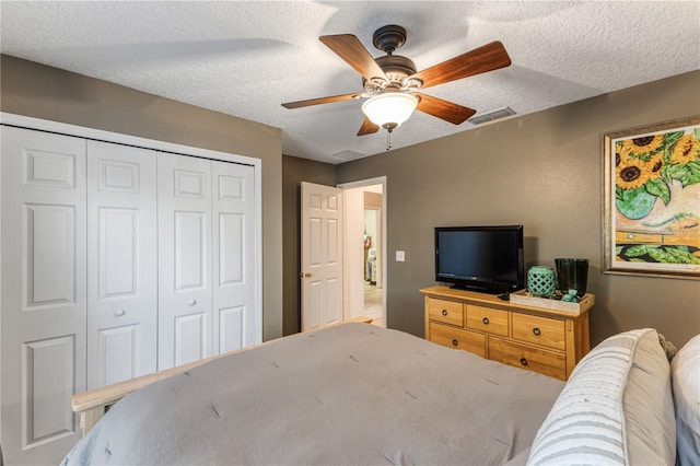 bedroom with ceiling fan, a closet, and a textured ceiling