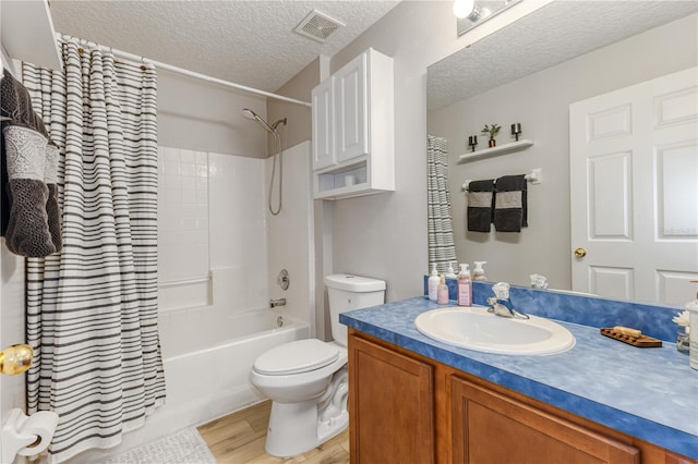 full bathroom with shower / tub combo with curtain, wood-type flooring, toilet, and a textured ceiling