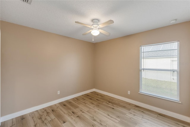 empty room featuring a textured ceiling, ceiling fan, and light hardwood / wood-style flooring