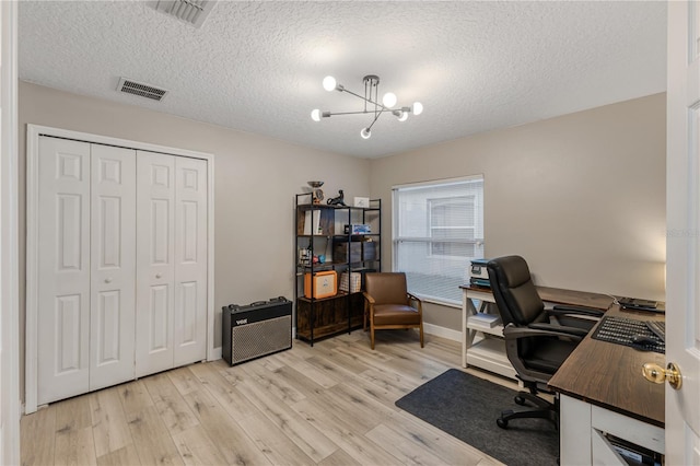 office area featuring an inviting chandelier, light hardwood / wood-style floors, and a textured ceiling