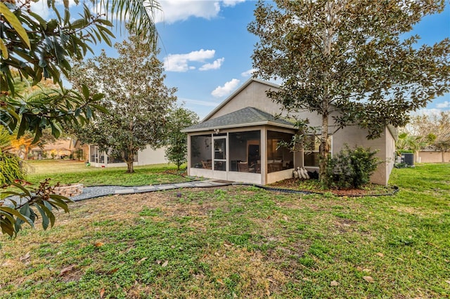 back of property with a yard and a sunroom