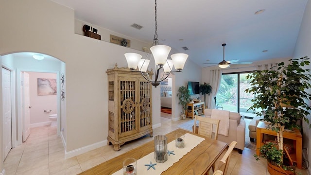 dining area with lofted ceiling, light tile patterned floors, and ceiling fan with notable chandelier