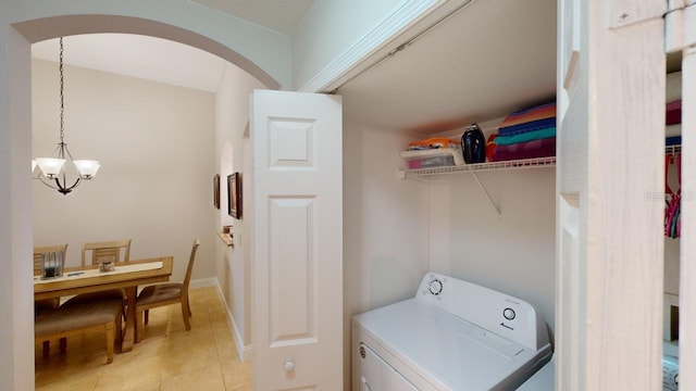 laundry area featuring washer / dryer, light tile patterned floors, and a notable chandelier