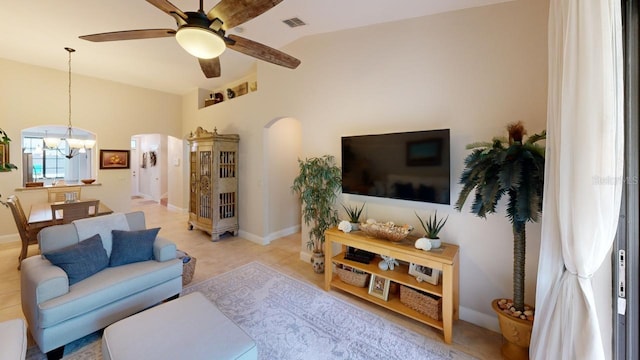 living room with vaulted ceiling and ceiling fan with notable chandelier