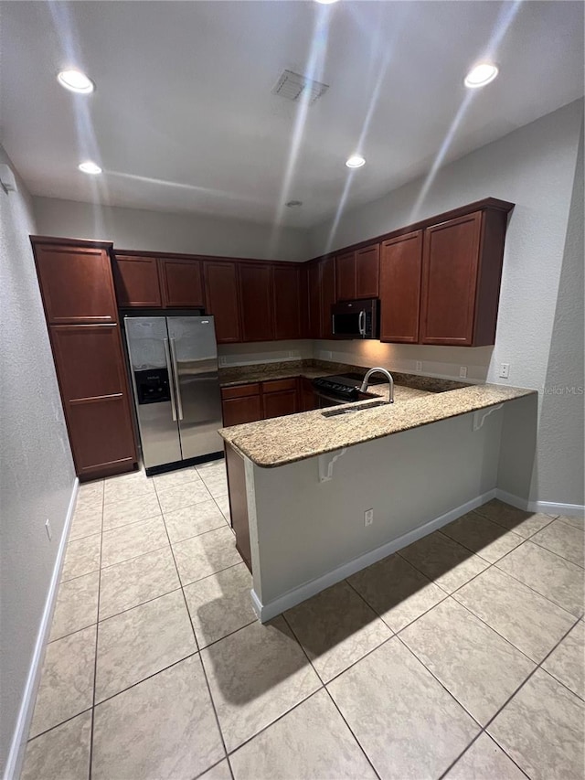 kitchen featuring light tile patterned floors, sink, a kitchen breakfast bar, stainless steel refrigerator with ice dispenser, and kitchen peninsula