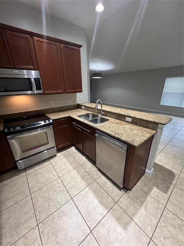 kitchen with sink, light stone counters, light tile patterned floors, appliances with stainless steel finishes, and kitchen peninsula