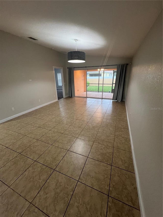 spare room featuring tile patterned flooring and a textured ceiling