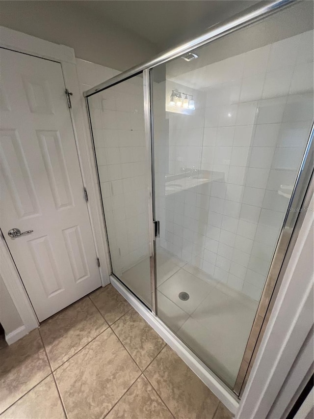 bathroom featuring an enclosed shower and tile patterned floors