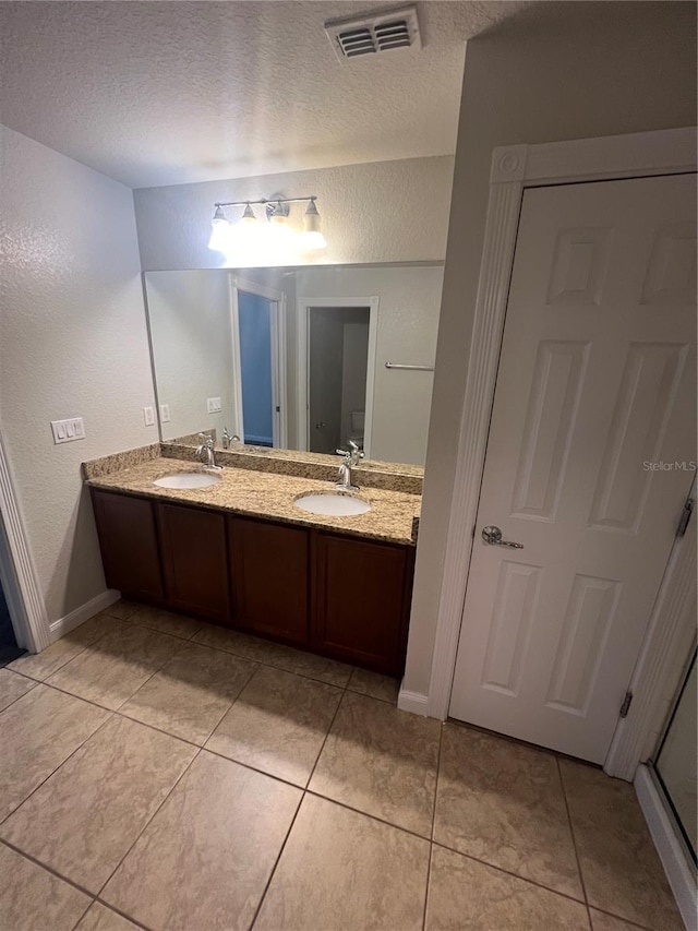 bathroom with vanity, tile patterned floors, and a textured ceiling