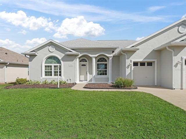 view of front of house with driveway, an attached garage, a shingled roof, stucco siding, and a front lawn