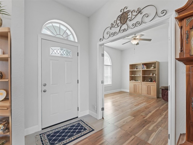 entryway featuring ceiling fan, baseboards, and wood finished floors