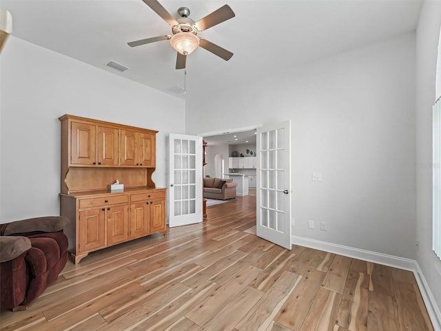 sitting room with light wood finished floors, visible vents, baseboards, french doors, and a ceiling fan