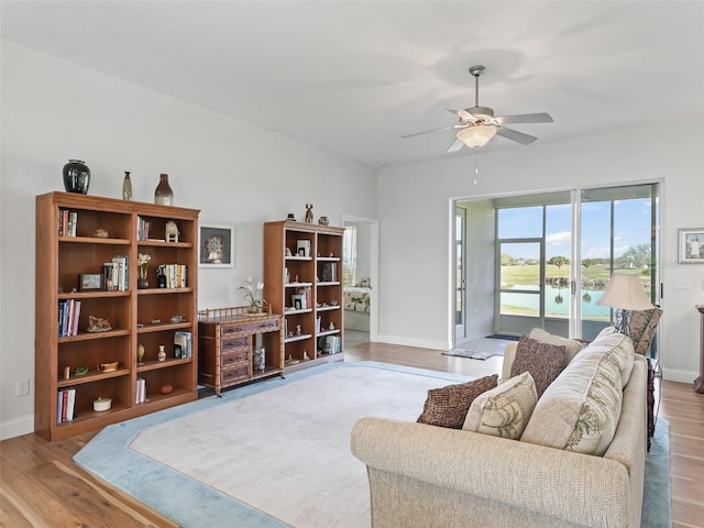 living area with ceiling fan, baseboards, and wood finished floors